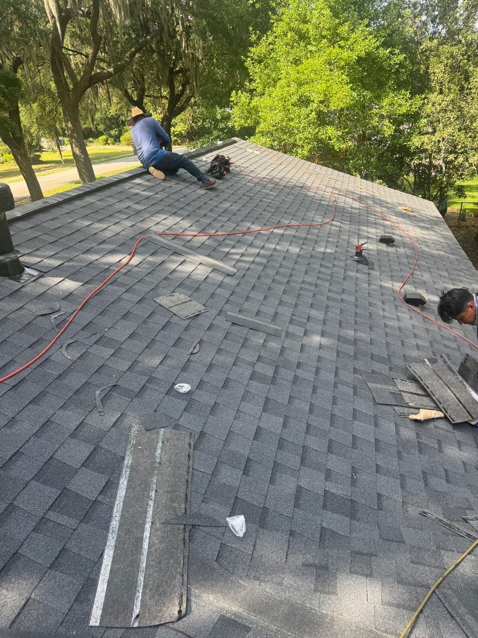 Completed shingle roof with a Tucker Contractors roofer on site