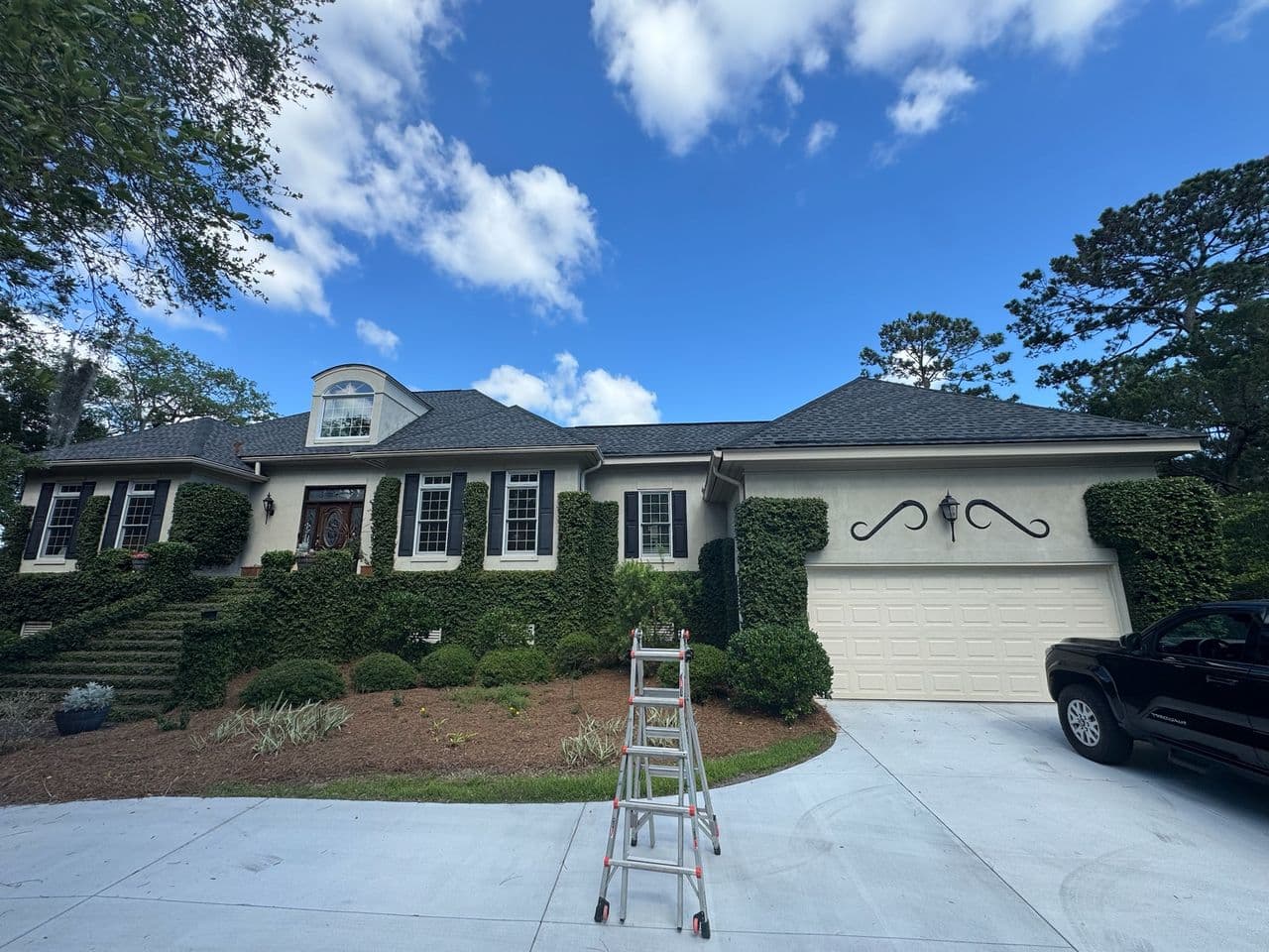 Residential home exterior with a new roof under a clear blue sky