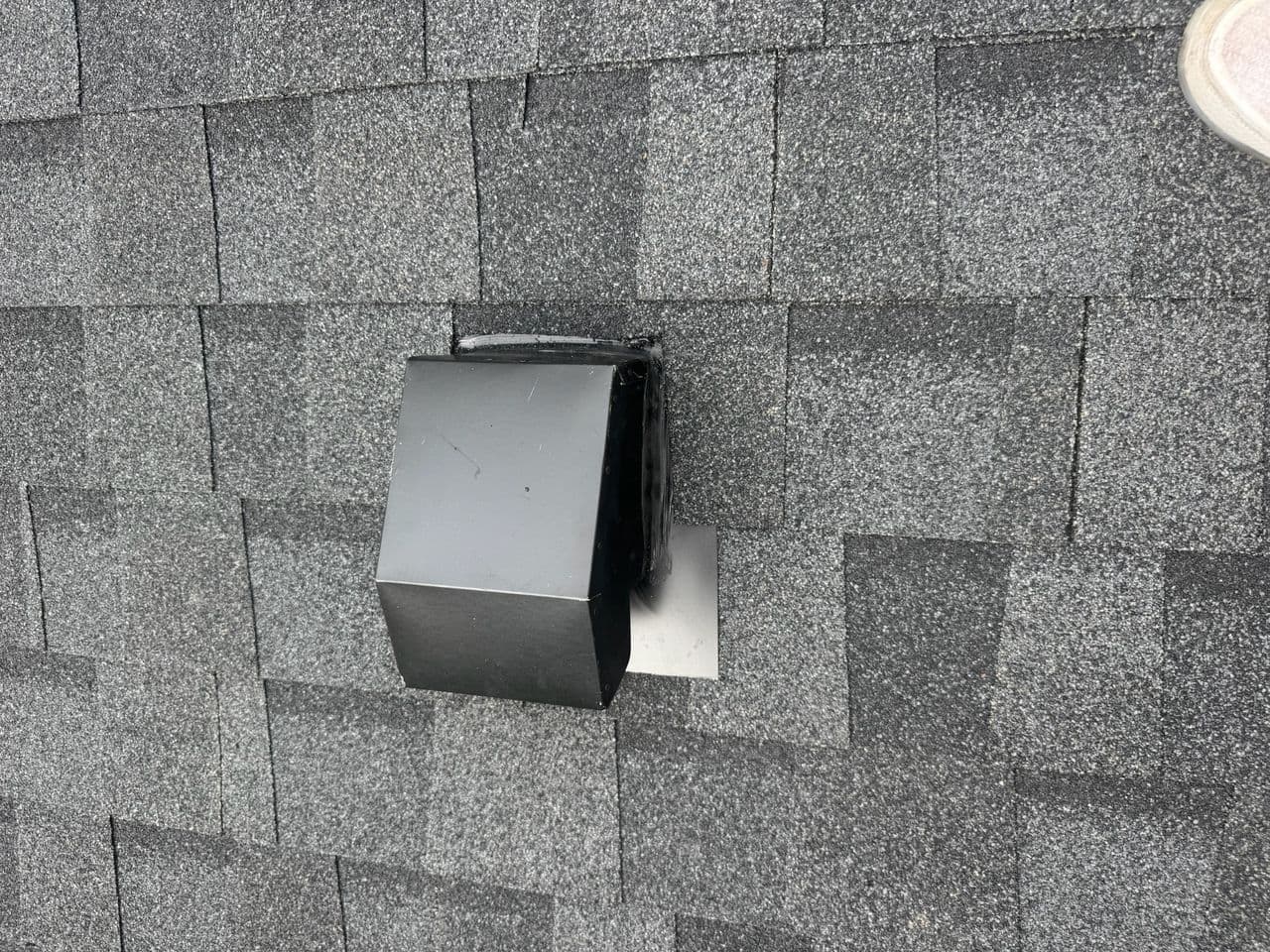 Close-up of roof vent flashing installed on new shingles