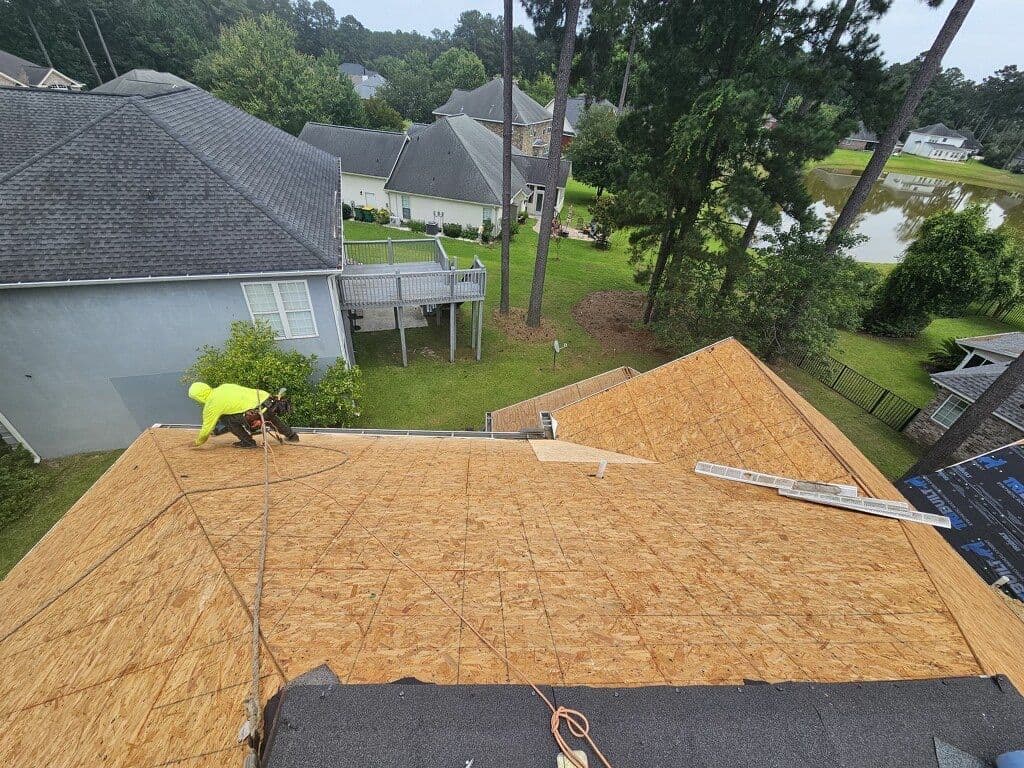 Roofing crew installing new plywood roof decking
