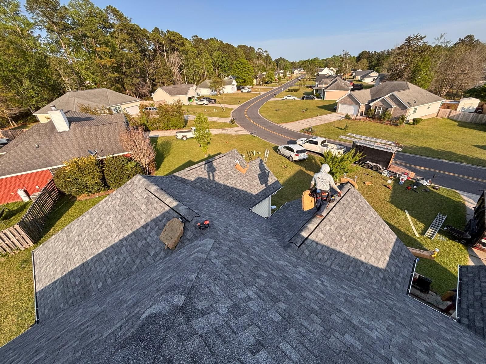 Aerial view of the Tucker Contractors crew installing a new architectural shingle roof on a residential home